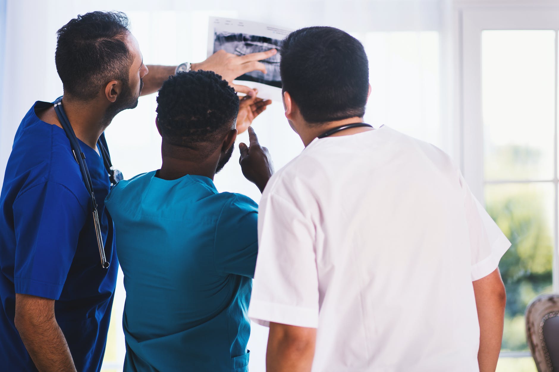 three person looking at x ray result